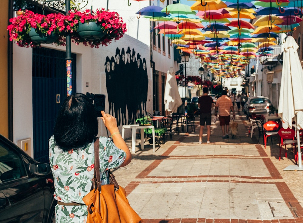 Mujer tomando foto de techos de paraguas