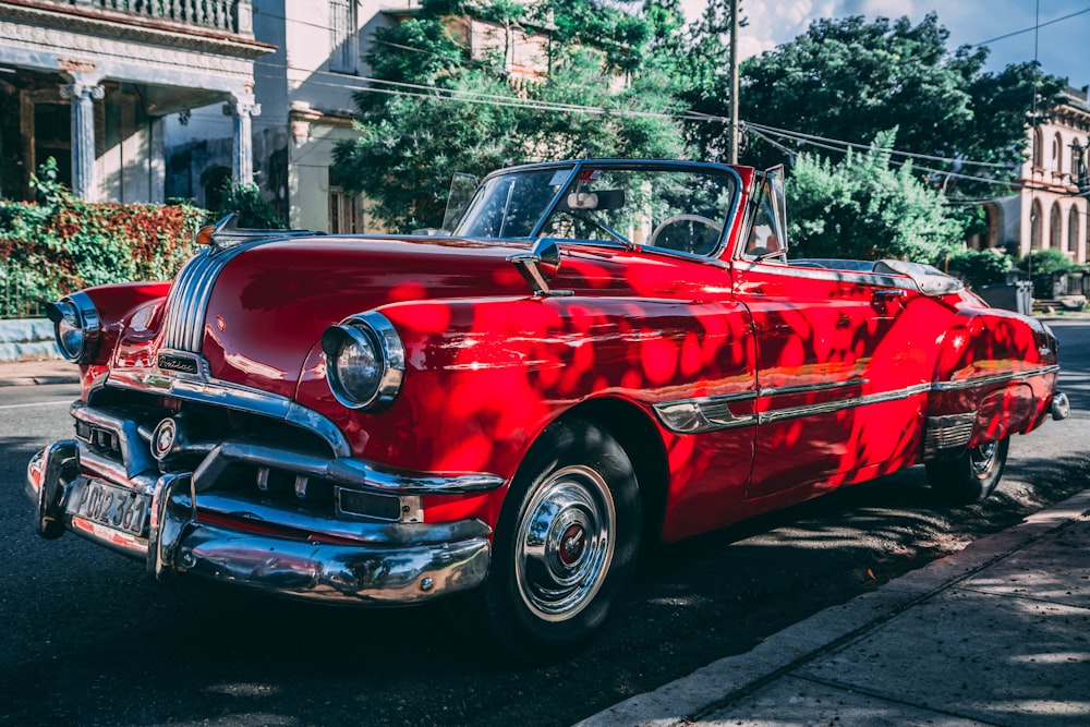 classic red convertible coupe parked beside road