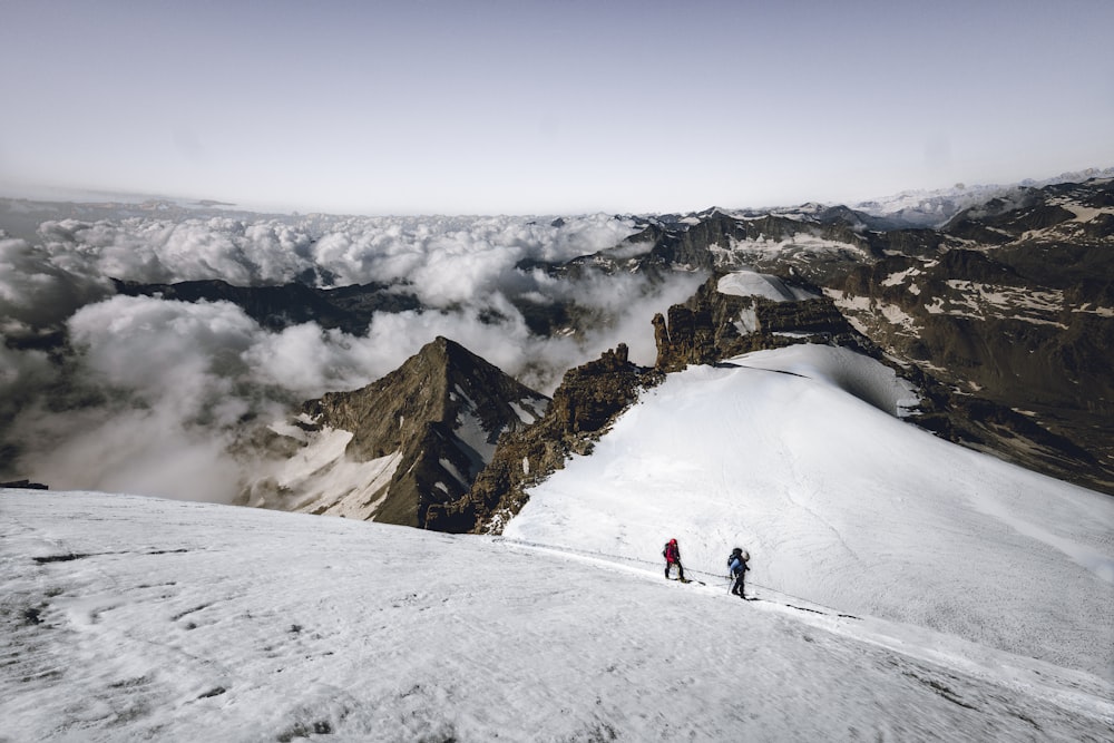 Dos personas caminando en la montaña cubierta de nieve