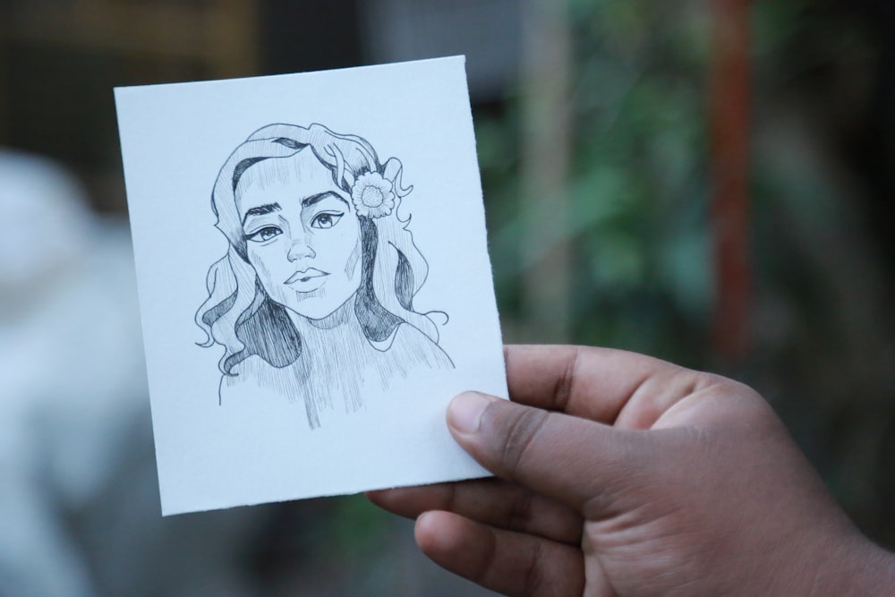 person holding sketch of a woman