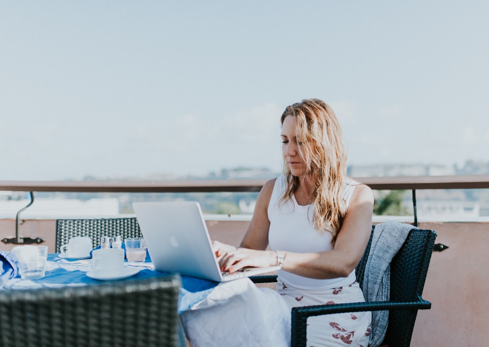 woman sitting on chair while using MacBook