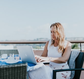 woman sitting on chair while using MacBook