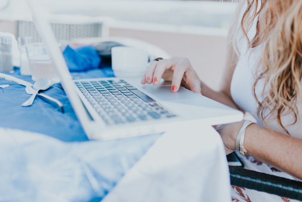 woman sitting near table using laptop computer