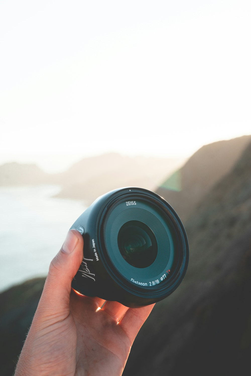 person holding camera lens shallow focus photography