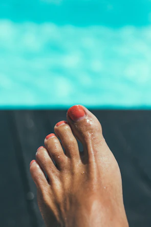 Artistic shot of painted toenails in vibrant colors posed on a vintage leather chair.