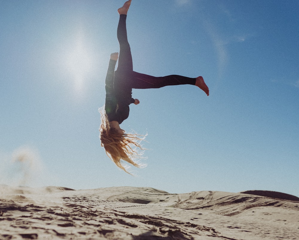 woman back flip under blue sky