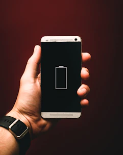 person holding low battery smartphone