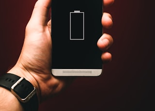person holding low battery smartphone