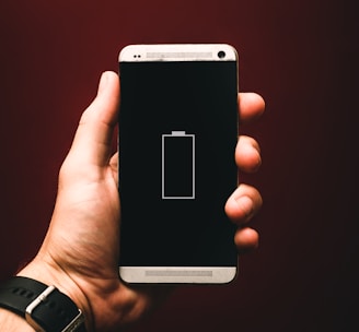 person holding low battery smartphone