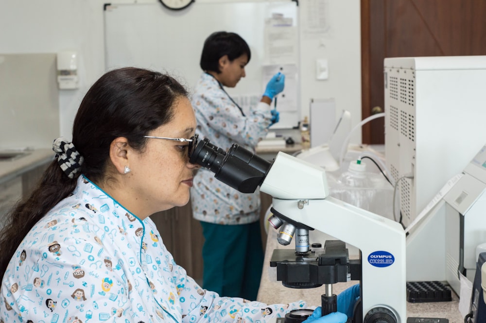 woman using black microscope