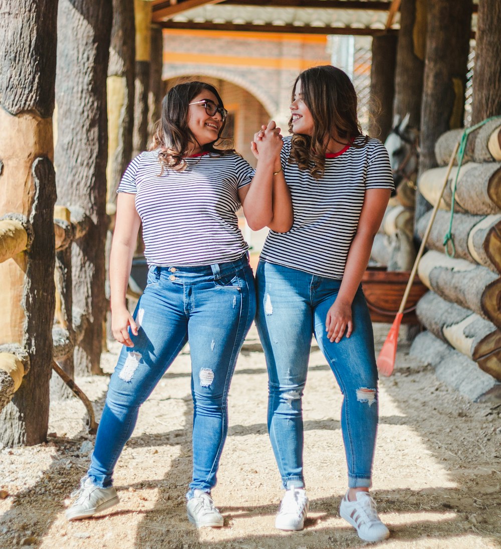 two smiling women while holding their hands at daytime