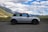 A comfortable rental car parked beside a picturesque mountain road in India.