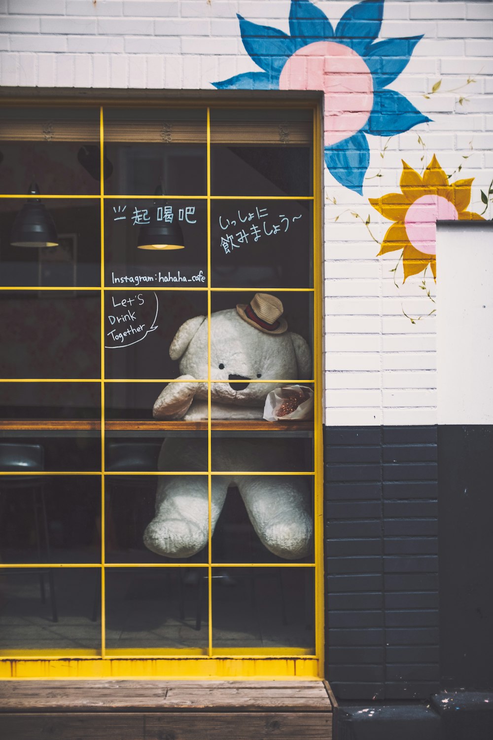 a large white teddy bear sitting in a window