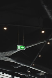 green emergency exit signage on ceiling