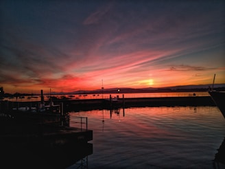 A vibrant bass boat docked at a marina with Lake Erie’s calm waters reflecting the sunset.