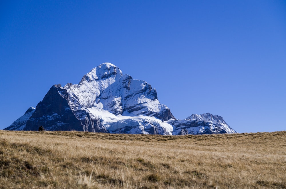 snow-covered mountain under blue and white skies during daytime