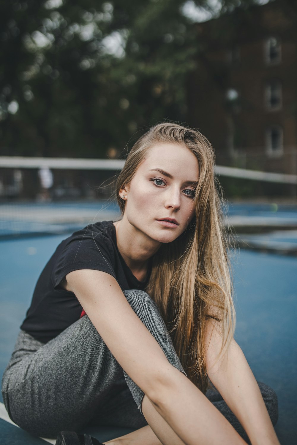 woman sitting near brown concrete building during daytime