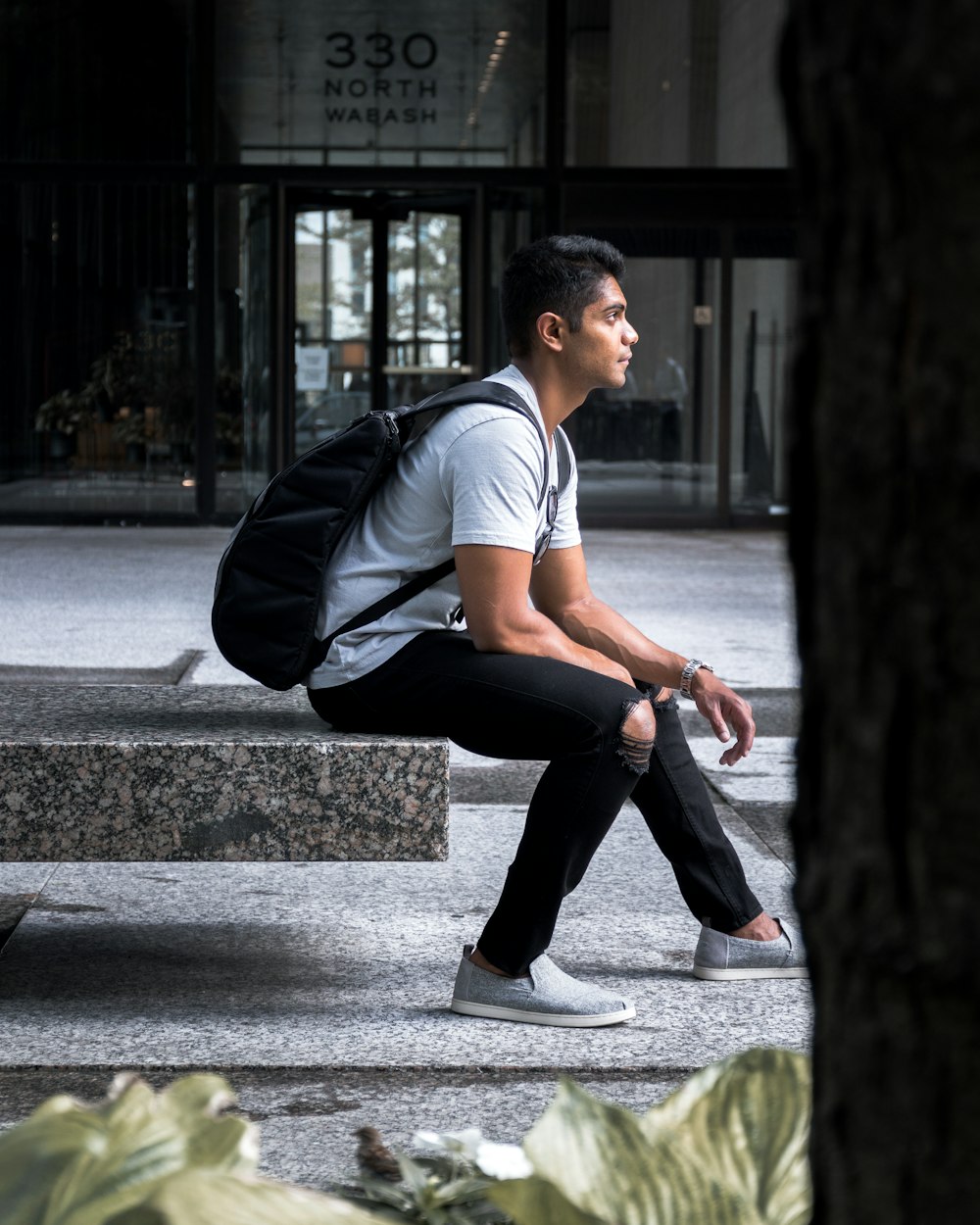 man sitting on black marble block at daytime