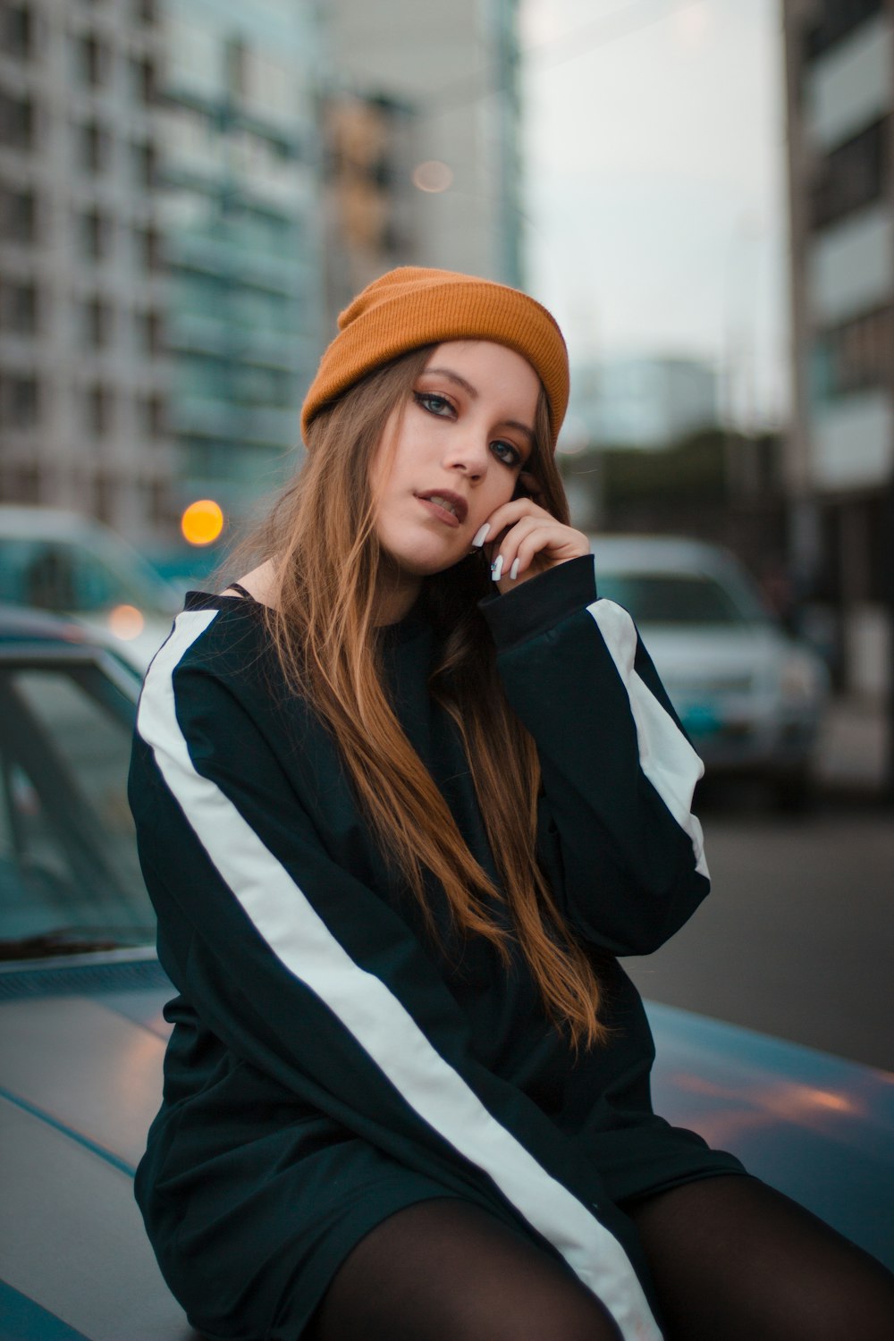 woman wearing orange knit cap while sitting on chair