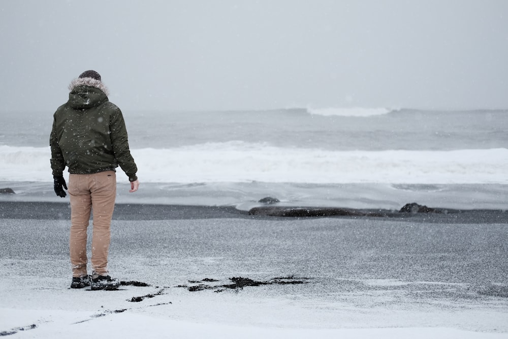 灰色のジャケットと茶色のジャケットを着た人が海岸に立っている