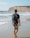 man walking on seashore near cliff