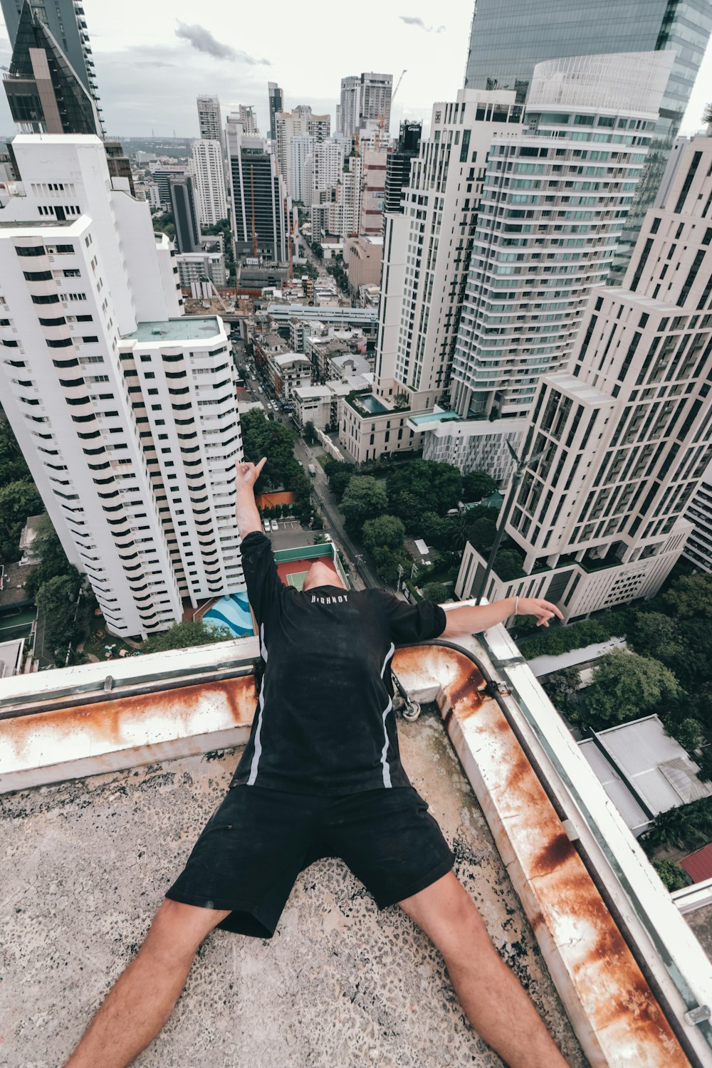 man lying on top of the building during daytime