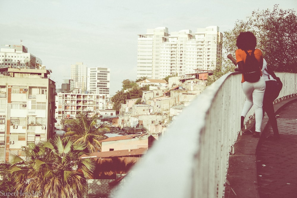 couples leaning on white metal handrails