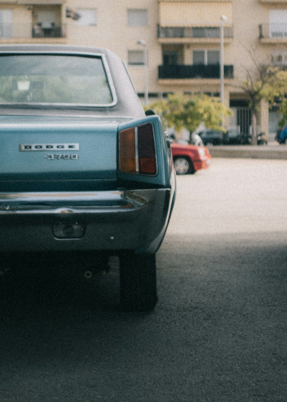 green Dodge 3700 car on gray concrete pavement during daytime