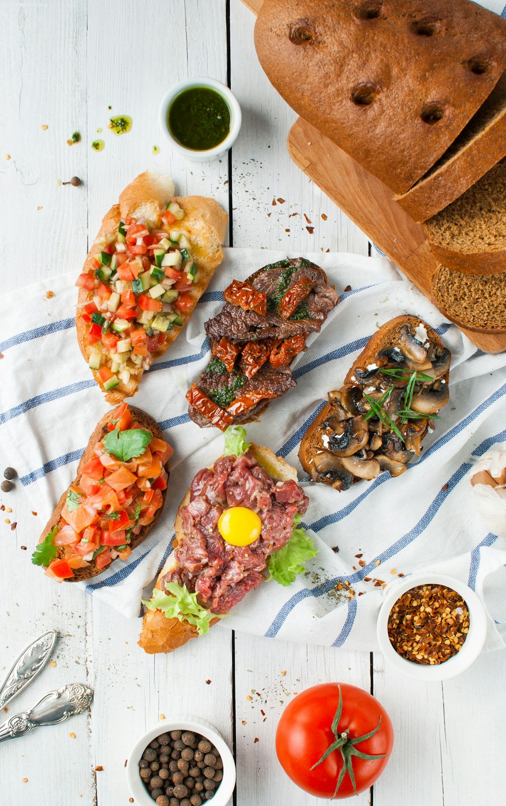 Flay-Lay-Fotografie von geschnittenem Brot mit Rindfleisch und Gemüse oben drauf und Dips