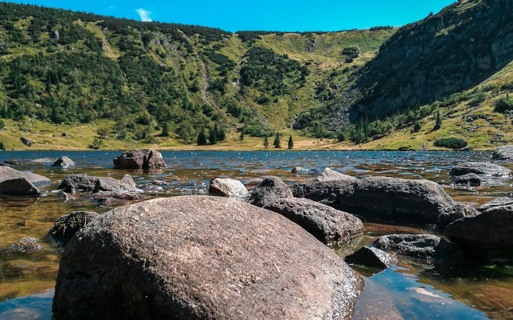 a lake surrounded by large rocks in a valley