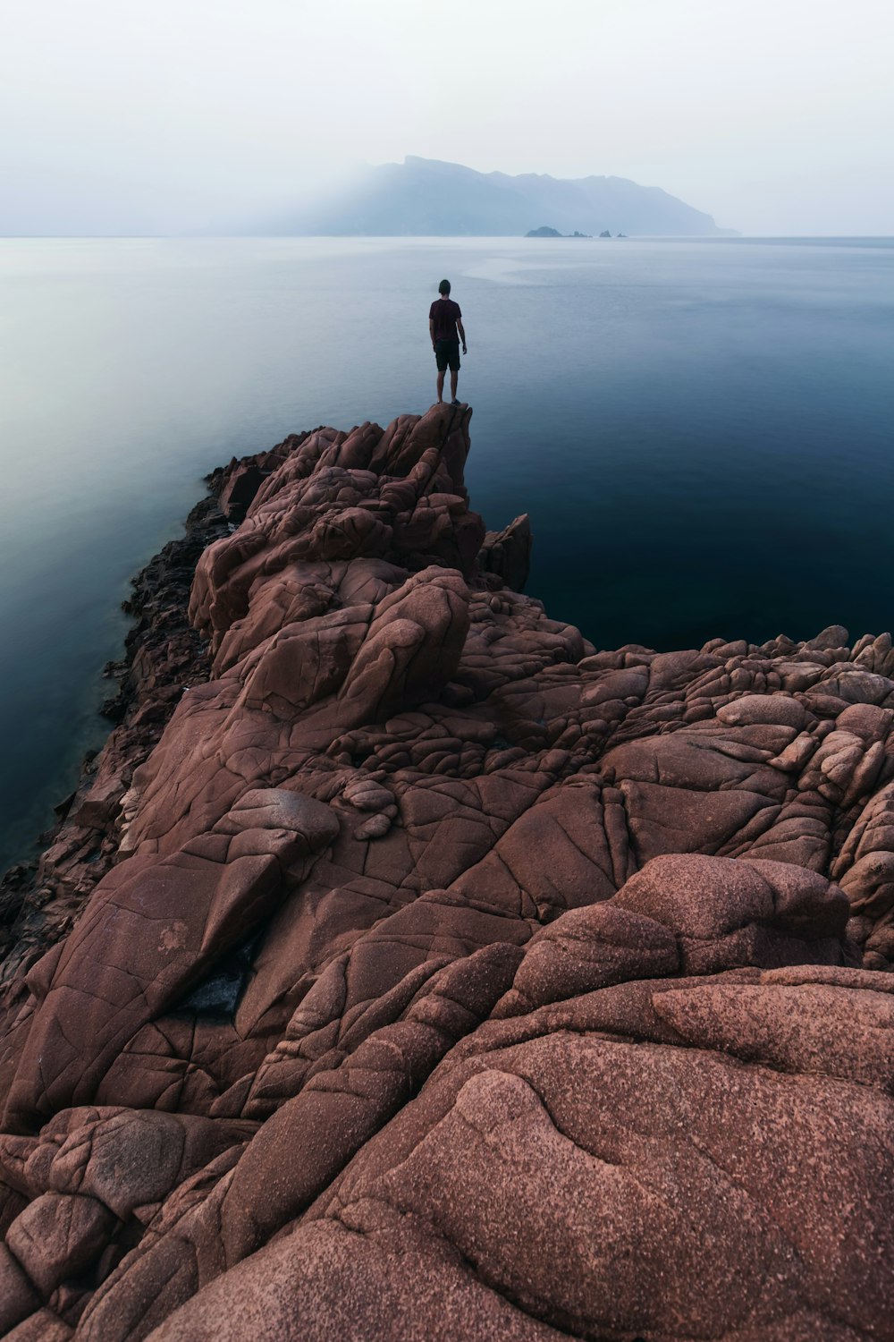 person standing on rock cliff