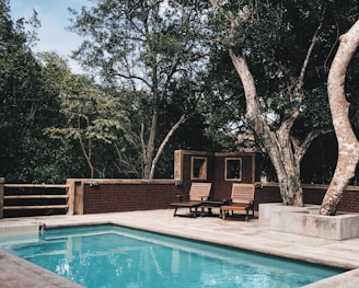 two lounge chairs near swimming pool