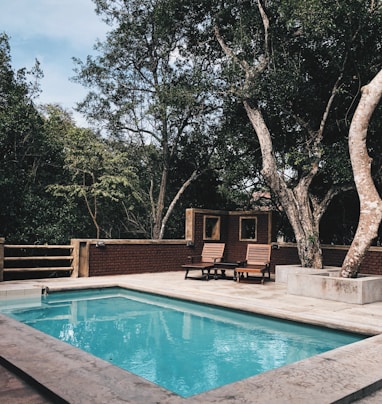 two lounge chairs near swimming pool