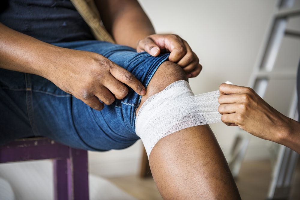 person bandaging the person while sitting down