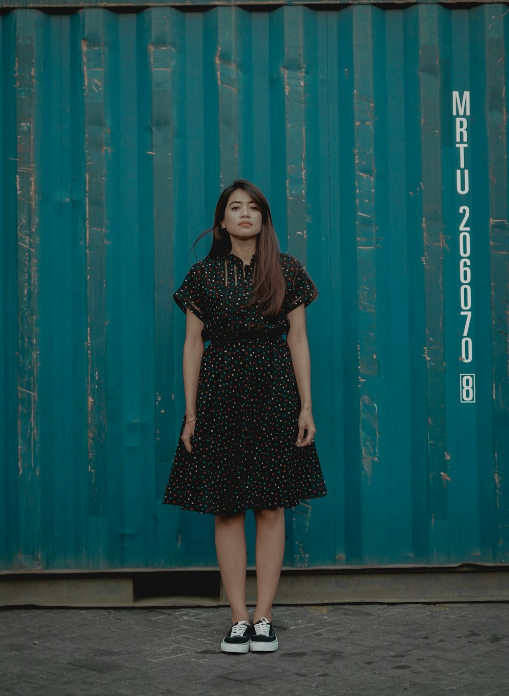 woman standing beside intermodal container