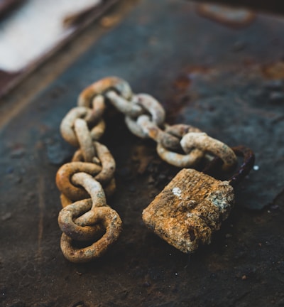 selective focus photography of gray rust-covered chain and padlock