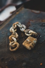 selective focus photography of gray rust-covered chain and padlock