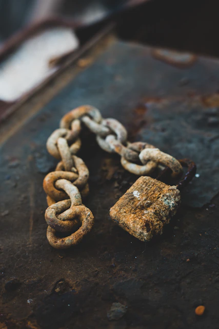 selective focus photography of gray rust-covered chain and padlock