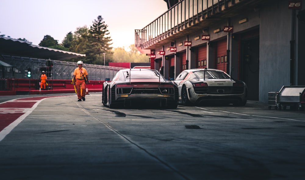 white coupe beside red coupe during daytime