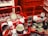 Two red shopping baskets are filled with cans resembling Campbell's soup, with stacked displays in the background. The setting appears vibrant and artistic, featuring classic pop art elements.