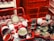 Two red shopping baskets are filled with cans resembling Campbell's soup, with stacked displays in the background. The setting appears vibrant and artistic, featuring classic pop art elements.