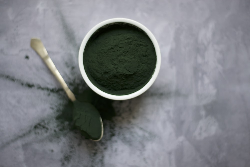 flat lay photography of green powder in pot