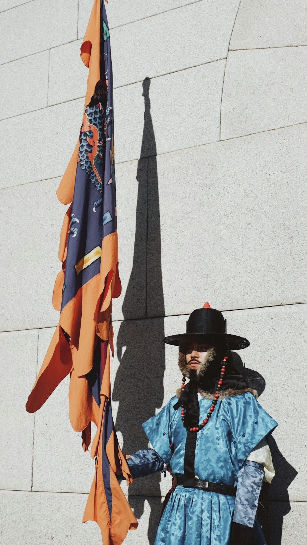 man holding orange and blue flag at daytime