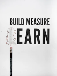 black pencil with build measure earn text overlay