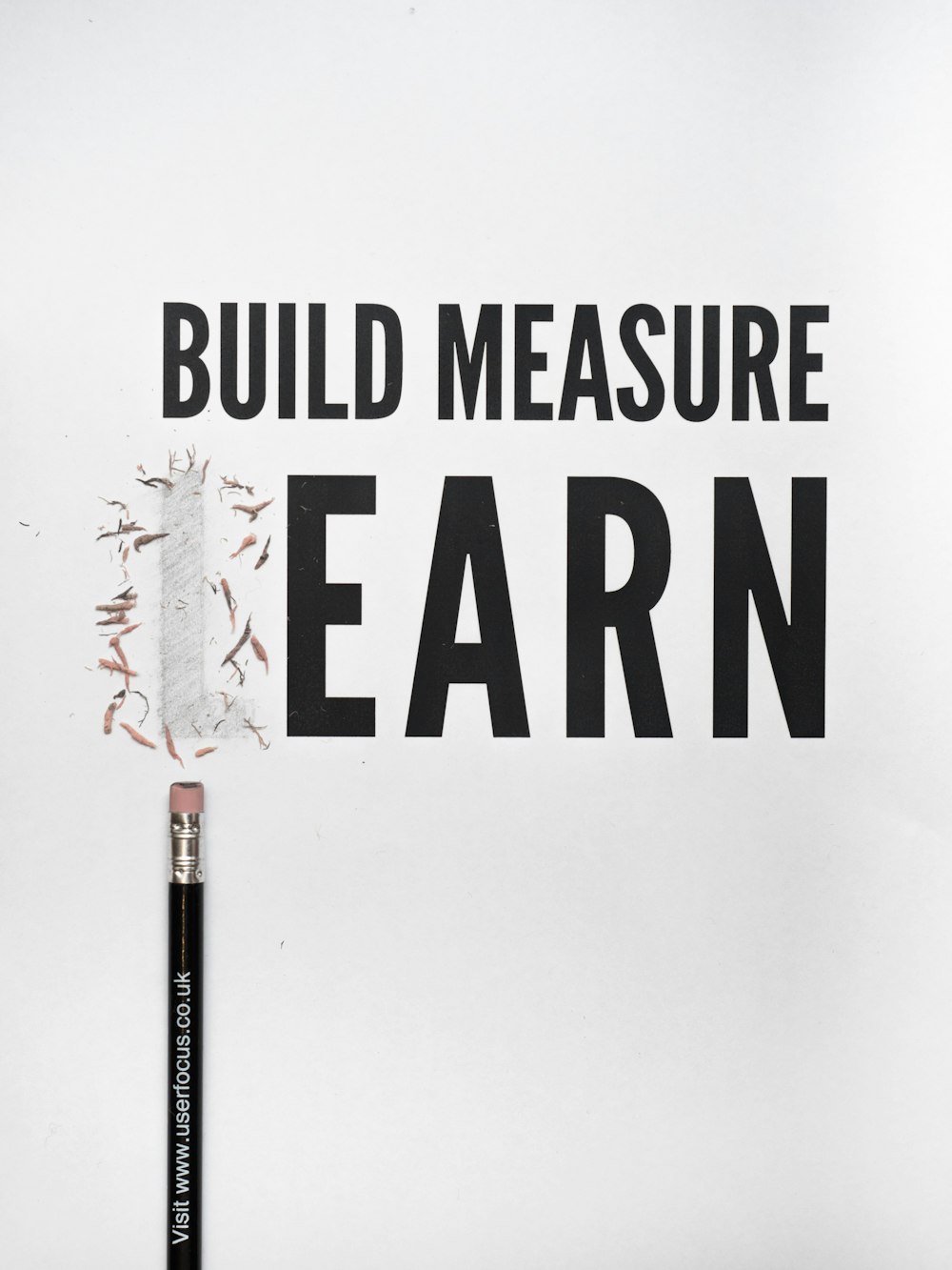 black pencil with build measure earn text overlay
