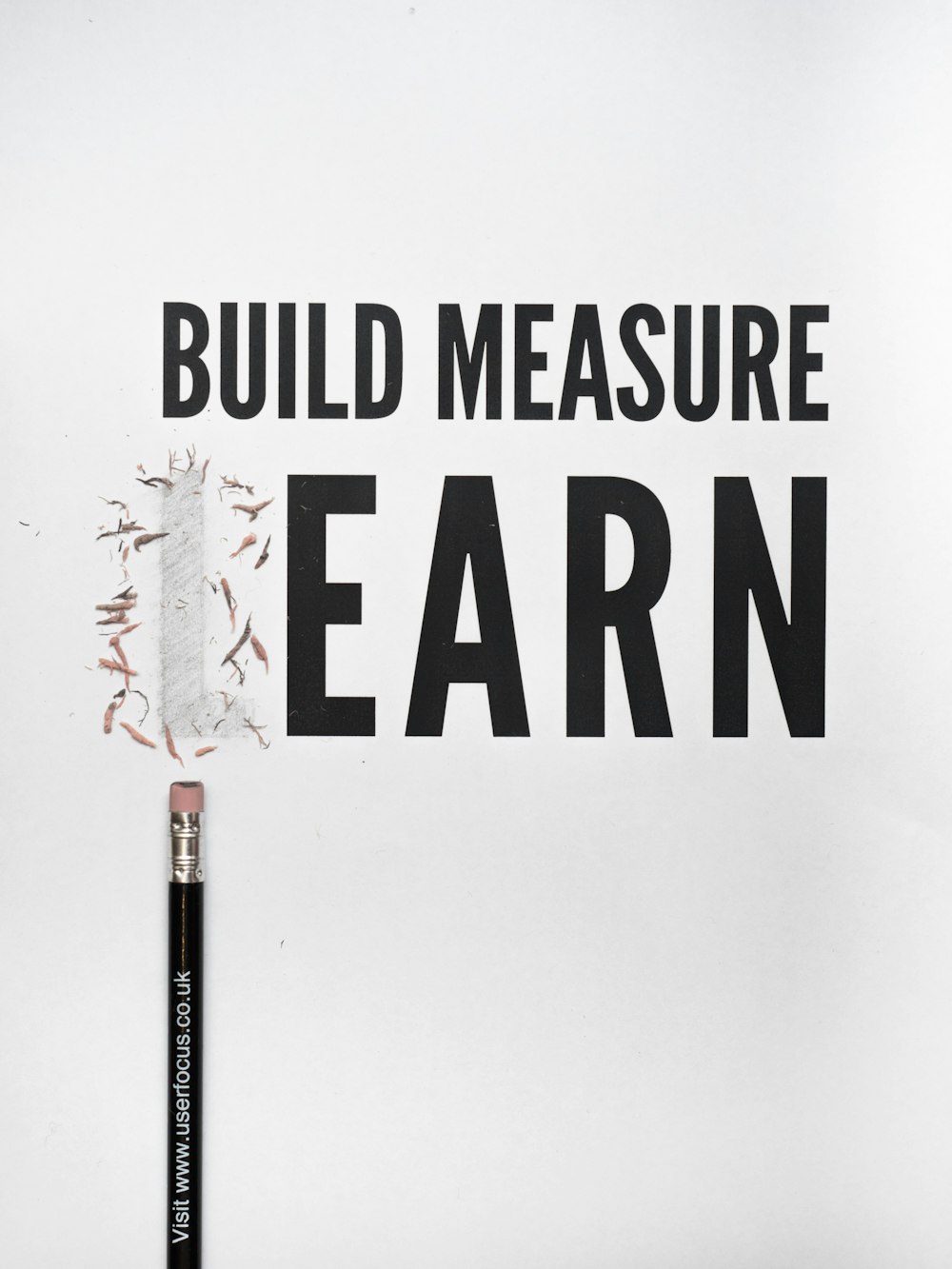 검은색 연필 with build measure earn text overlay