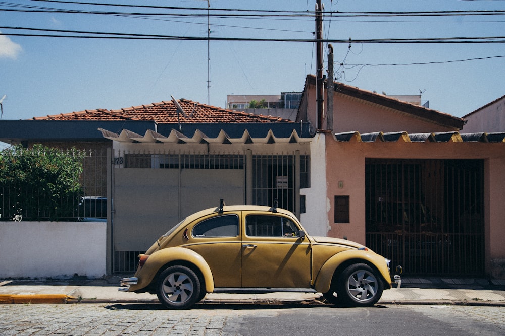 Volskwagen Beetle beige estacionado afuera de la casa