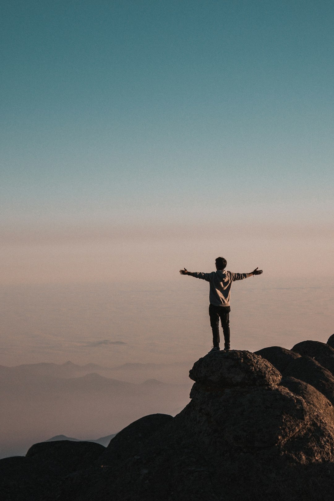 man standing beside cliff