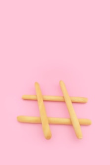 four brown wooden sticks on pink surface