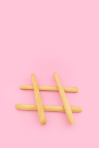 four brown wooden sticks on pink surface